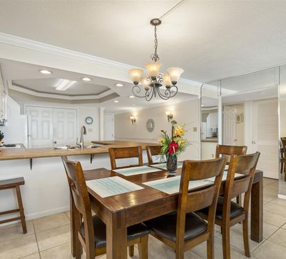 Gather around your spacious dining table where warm wood tones and elegant chandeliers create perfect moments for shared meals and conversations.