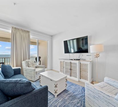 Relax in your bright living room with ocean views streaming through floor-to-ceiling windows. Sink into plush seating while enjoying coastal breezes from your private balcony.