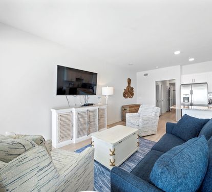 Relax in your bright, coastal-inspired living space with plush seating and an open kitchen perfect for preparing meals together.