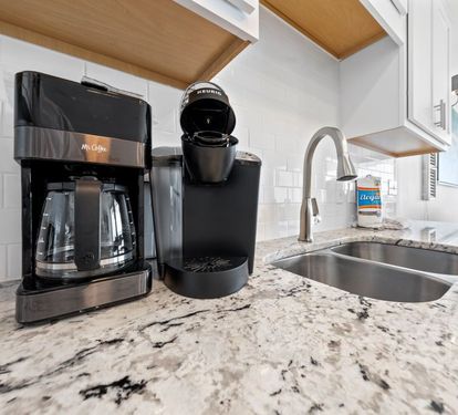 Start your mornings right with premium coffee makers and Keurig at your fingertips in this beautiful granite kitchen.