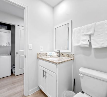 Fresh towels await in your pristine bathroom, complete with granite countertops and convenient laundry access.