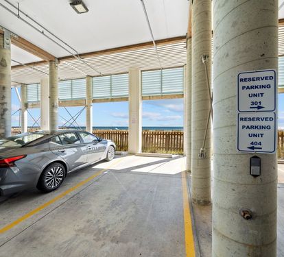 Your reserved parking spot ensures convenient access to your beachfront getaway, with the ocean just steps away from this covered garage.