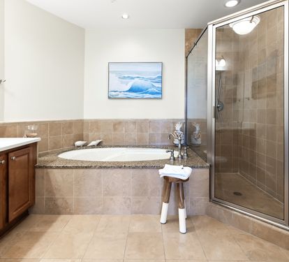Your spa-like bathroom features a soaking tub and walk-in shower, perfect for unwinding after exploring. Coastal artwork and warm tones create a soothing retreat.