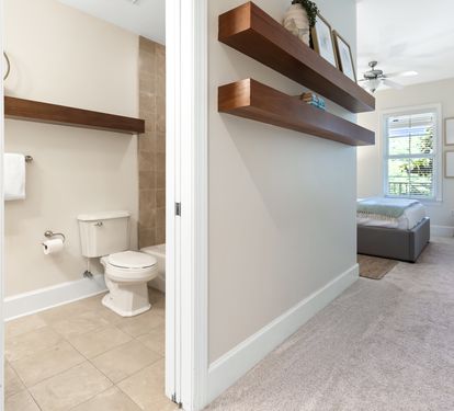 Your private retreat features open floating shelves, a cozy seating nook, and an en-suite bathroom with a walk-in shower, all bathed in soft natural light.