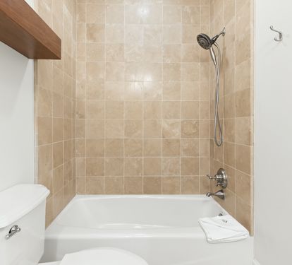 Step into your private bathroom featuring a tub-shower combo with elegant beige tile, perfect for unwinding after a day of adventure.