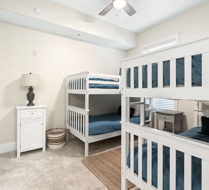 Bright bedroom with two white bunk beds, perfect for the kids to enjoy their own cozy retreat during your family getaway.
