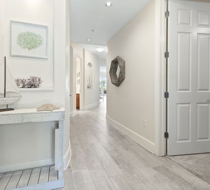 Step inside your serene coastal retreat, where whitewashed wood and nautical touches welcome you into a peaceful haven. The light-filled hallway invites you to unwind and discover your home away from home.