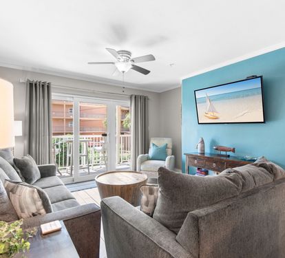 Unwind in your bright living room with plush seating, breezy ceiling fan, and coastal touches that set the tone for your beach getaway.