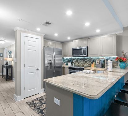 Fully equipped kitchen with granite countertops, stainless appliances, and a spacious island perfect for meal prep or gathering over morning coffee.