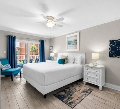 Serene primary bedroom where a plush king bed awaits, framed by soothing coastal tones. Soft lighting and beachy artwork set the mood for your restful retreat.