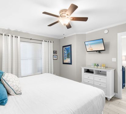 Your restful retreat features a plush bed, ceiling fan, and fresh coastal touches that invite you to unwind in comfort.