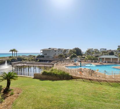 Stunning beachfront resort community with sparkling pool facilities and coastal views. Property buildings nestled among palm trees near pristine shoreline.
