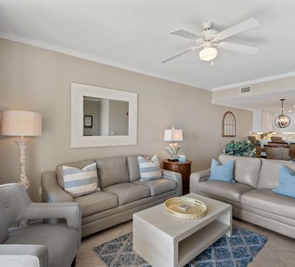 You'll love unwinding in this sophisticated living space, where plush gray sofas and coastal blue accents create your perfect retreat.