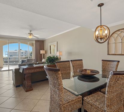 Gather around the elegant dining table with wicker chairs, where natural light floods in through arched windows overlooking the neighborhood.