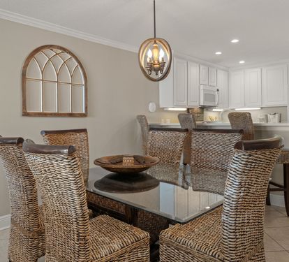 Dining space features wicker chairs around a glass table, perfect for memorable meals together.