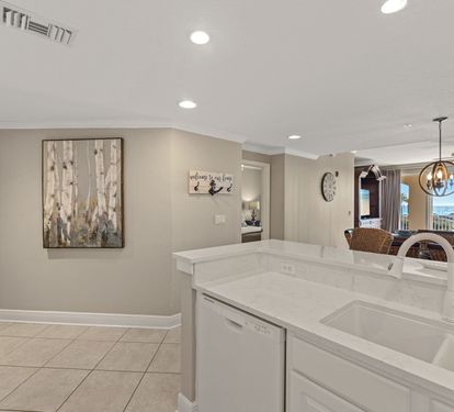 The modern kitchen flows seamlessly into the dining area, featuring gleaming quartz counters and sleek appliances for memorable meals together.