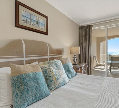 The elegant Primary bedroom features coastal colors and a private balcony where you'll wake to beautiful views each morning.
