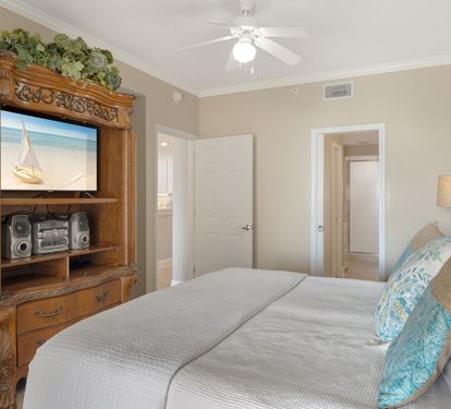 Relax in the peaceful bedroom with coastal charm, featuring a comfortable bed and entertainment center for cozy evenings in.