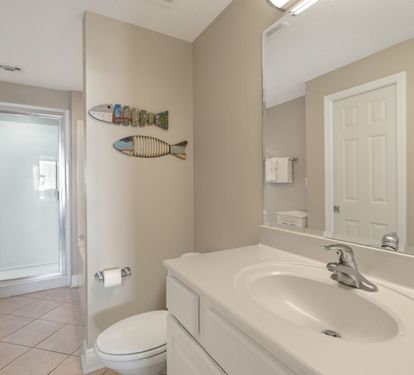 Step into the serene Primary bathroom with coastal touches and a refreshing shower to wash away the day's adventures.