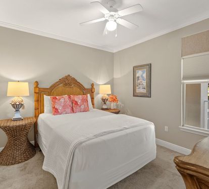 Rest peacefully in the cozy bedroom featuring crisp linens, warm wicker accents, and gentle ceiling fan breezes.