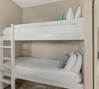 Cozy bunk beds with crisp white linens and cheerful blue accents create the perfect space for your family's comfort.