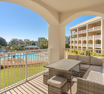 Relax on the private balcony with wicker seating while enjoying views of the sparkling pool and lush resort grounds.