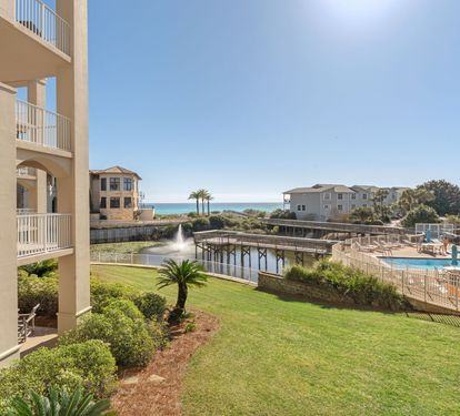 Beachfront resort community with swimming pool, landscaped grounds, and coastal access via boardwalk.
