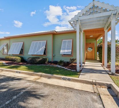Charming vacation rental with tropical landscaping and welcoming covered entrance in a peaceful residential setting.