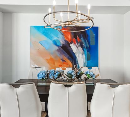 Your elegant dining space features a striking chandelier and bold artwork, perfect for memorable meals with loved ones.
