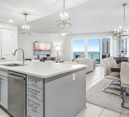Your gourmet kitchen flows seamlessly into the open living space, where ocean views frame every moment of your beachfront getaway.