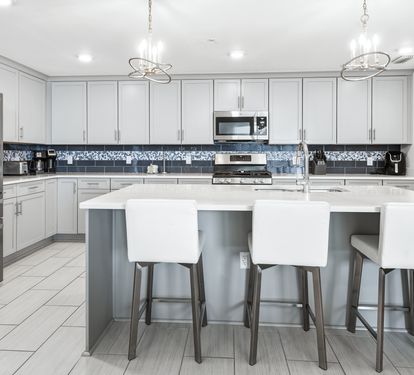 Your gourmet kitchen awaits with gleaming quartz countertops, modern appliances, and stylish island seating for memorable meal prep and casual dining.