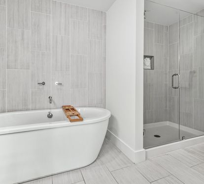 Unwind in your spa-like bathroom with a luxurious soaking tub and modern glass shower, featuring elegant tile work throughout.