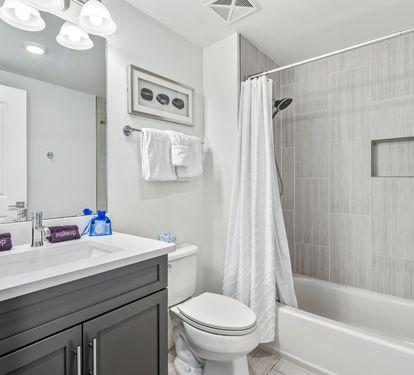 Unwind in your pristine bathroom featuring elegant tiling, modern fixtures, and thoughtful amenities for your comfort.