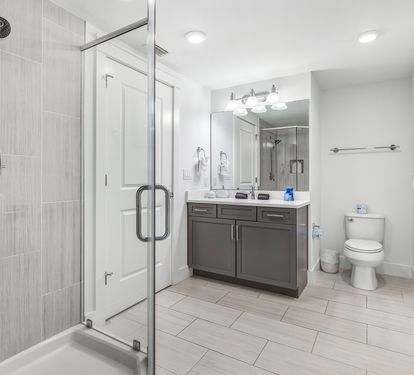 Step into your sleek modern bathroom with spacious glass-enclosed shower and ample vanity space for your morning routine.