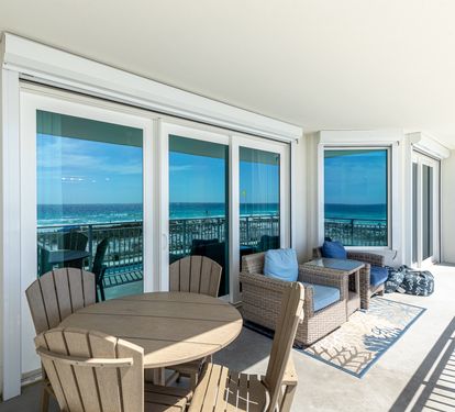 Your private covered terrace opens to stunning ocean views, complete with dining table and lounge seating for seaside relaxation.