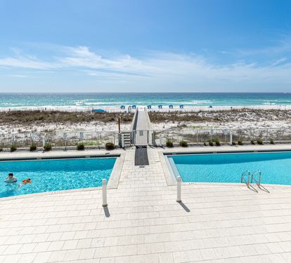Expansive beachfront pool deck with direct beach access and stunning Gulf Coast views creates the perfect vacation setting.