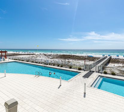 Beachfront pools feature crystal-clear water with direct access to pristine white sand and turquoise Gulf waters.