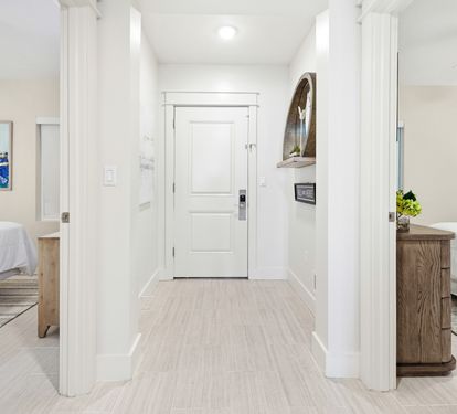 Step into your bright, modern hallway connecting two comfortable bedrooms with clean white walls and warm wood finishes throughout.