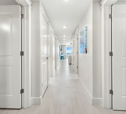 Step into your bright, elegant hallway with gleaming floors and modern touches that lead to your comfortable living spaces.