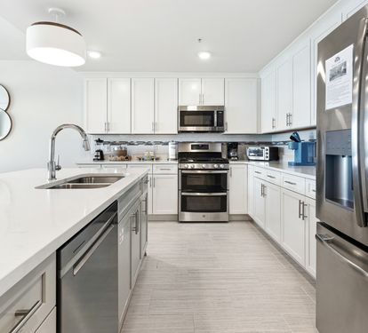 Your sleek kitchen features stainless steel appliances, quartz countertops, and everything needed for culinary adventures.
