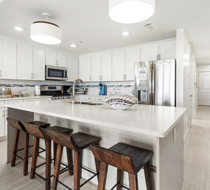 Your sleek kitchen features modern appliances, quartz counters, and a spacious island for cooking and casual dining together.