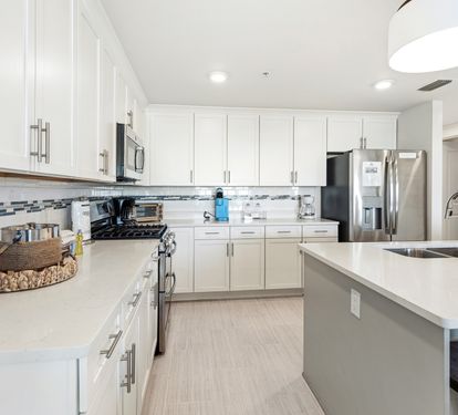 Your spacious kitchen awaits with gleaming white cabinets, stainless steel appliances, and ample counter space for cooking memorable vacation meals.