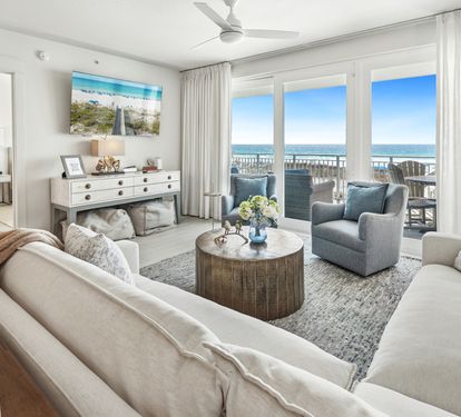 Sink into plush coastal comfort where your living room opens to breathtaking ocean views through floor-to-ceiling windows.