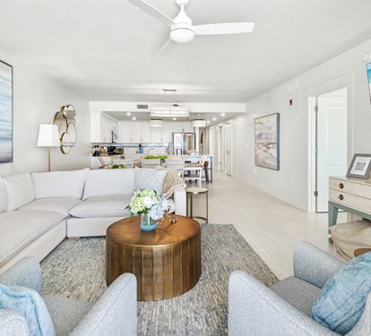Sink into plush seating surrounded by coastal blues and modern comfort, where your open-concept space flows seamlessly into a bright kitchen.