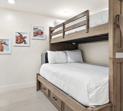 Your kids will love this cozy bunk room with whimsical sea creature art and plenty of space to dream.
