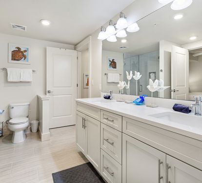 Unwind in your spacious master bathroom with dual vanities, gleaming countertops, and a refreshing glass-enclosed shower after your beach adventures.