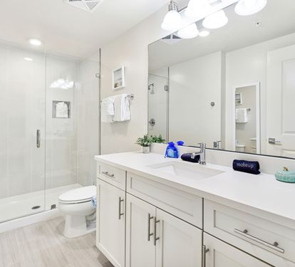 Refresh in your spacious modern bathroom with a glass-enclosed shower, dual vanities, and pristine white finishes that create a spa-like retreat.