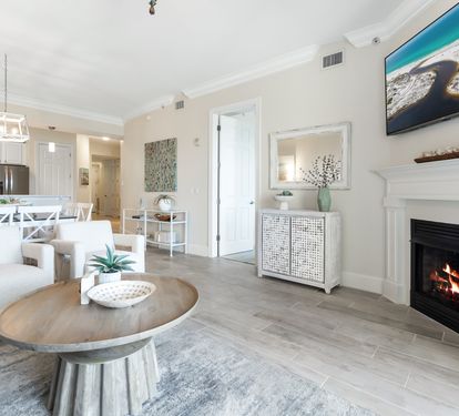 Unwind in your spacious open-concept living area, complete with a cozy fireplace, modern kitchen, and coastal décor that invites relaxation and memorable gatherings.