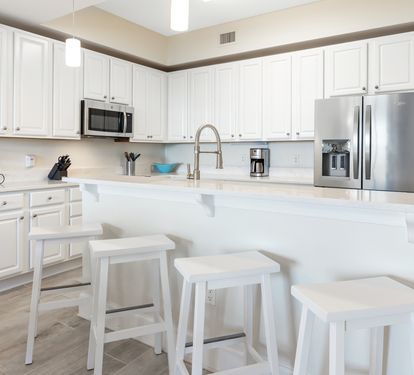 Bright, modern kitchen with gleaming countertops, stainless steel appliances, and a welcoming island where you can gather for meals or morning coffee.