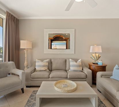 Unwind in your serene living room with plush seating, coastal decor, and natural light streaming through expansive windows.
